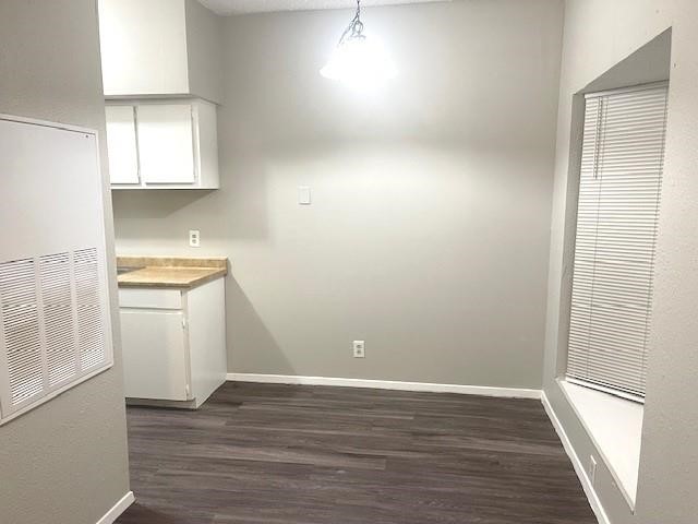 3316 Guadalupe Street, Unit 209 Austin, TX 78705 - Photo 5 of 12 Unfurnished dining area featuring dark wood-style flooring and baseboards