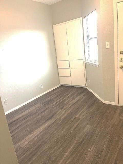 3316 Guadalupe Street, Unit 209 Austin, TX 78705 - Photo 7 of 12 Unfurnished bedroom with dark wood-type flooring and a closet