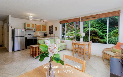 a living room with stainless steel appliances kitchen island furniture and a large window