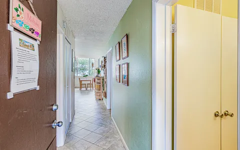 a view of a hallway with wooden floor and windows