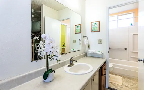 a bathroom with a granite countertop sink and a mirror