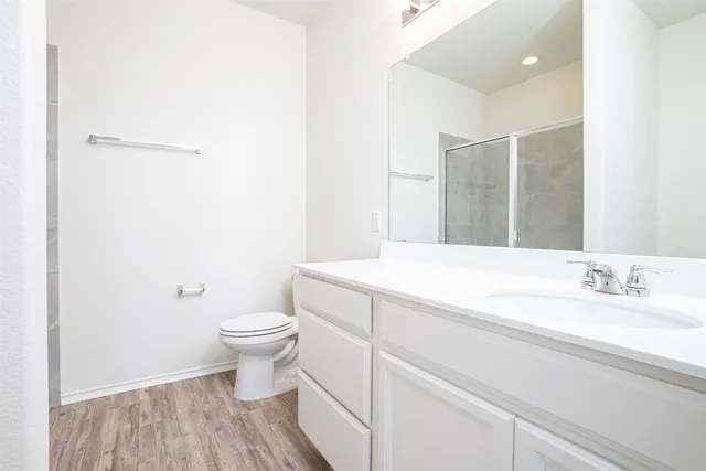 a bathroom with a granite countertop toilet and a sink
