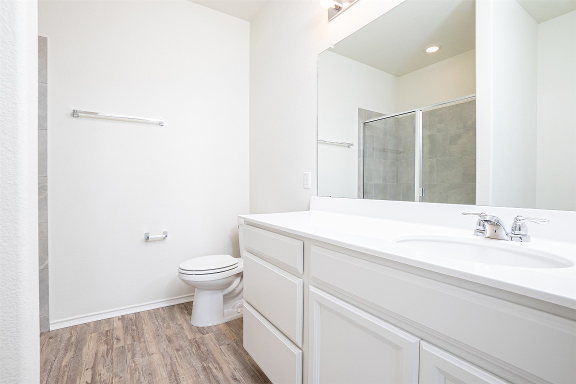 237 Yellowbark Street Buda, TX 78610 - Photo 20 of 28 a bathroom with a sink a toilet and a mirror