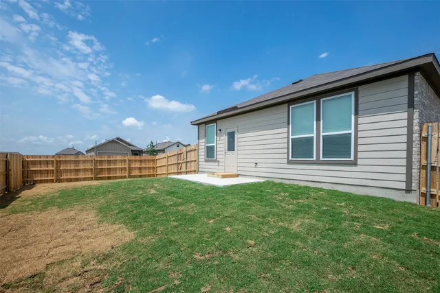 a view of a house with a yard and wooden fence