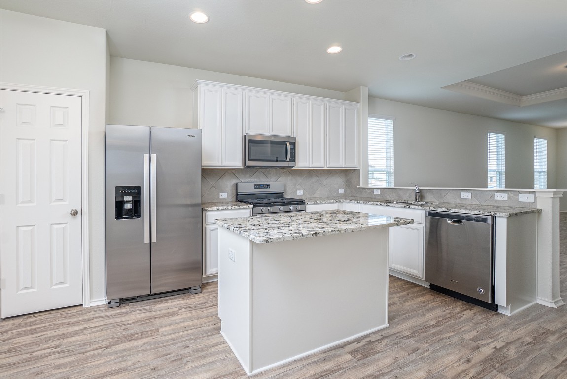 237 Yellowbark Street Buda, TX 78610 - Photo 7 of 28 a kitchen with stainless steel appliances granite countertop a refrigerator stove and sink