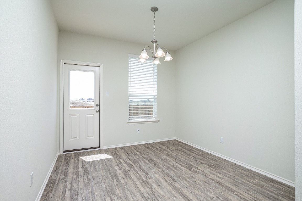 237 Yellowbark Street Buda, TX 78610 - Photo 9 of 28 wooden floor in an empty room with a window
