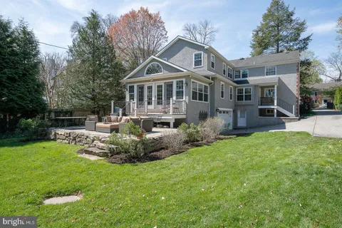 a front view of a house with a garden and trees