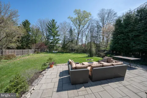 a view of a house with a yard chairs and table in the garden