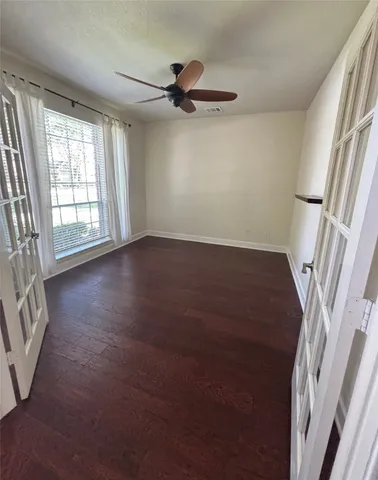 a large kitchen with kitchen island granite countertop a stove a sink a refrigerator and white cabinets