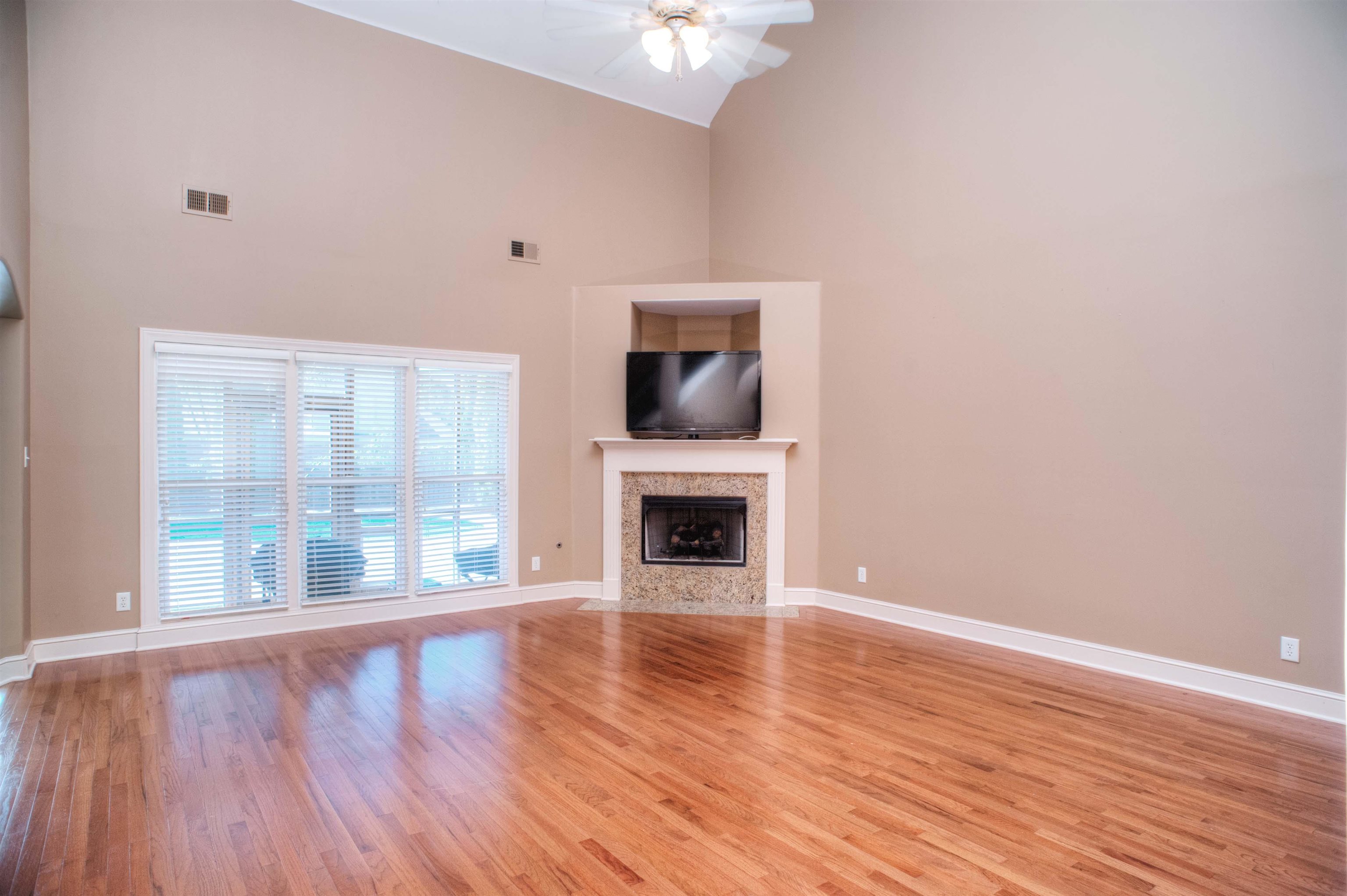 495 Tribal Woods Road Collierville, TN 38017 - Photo 4 of 22 18x17 Living Room with 28 ft Vaulted Ceiling, Hardwood, and Corner Gas Log Fireplace with Granite Hearth and TV Insert