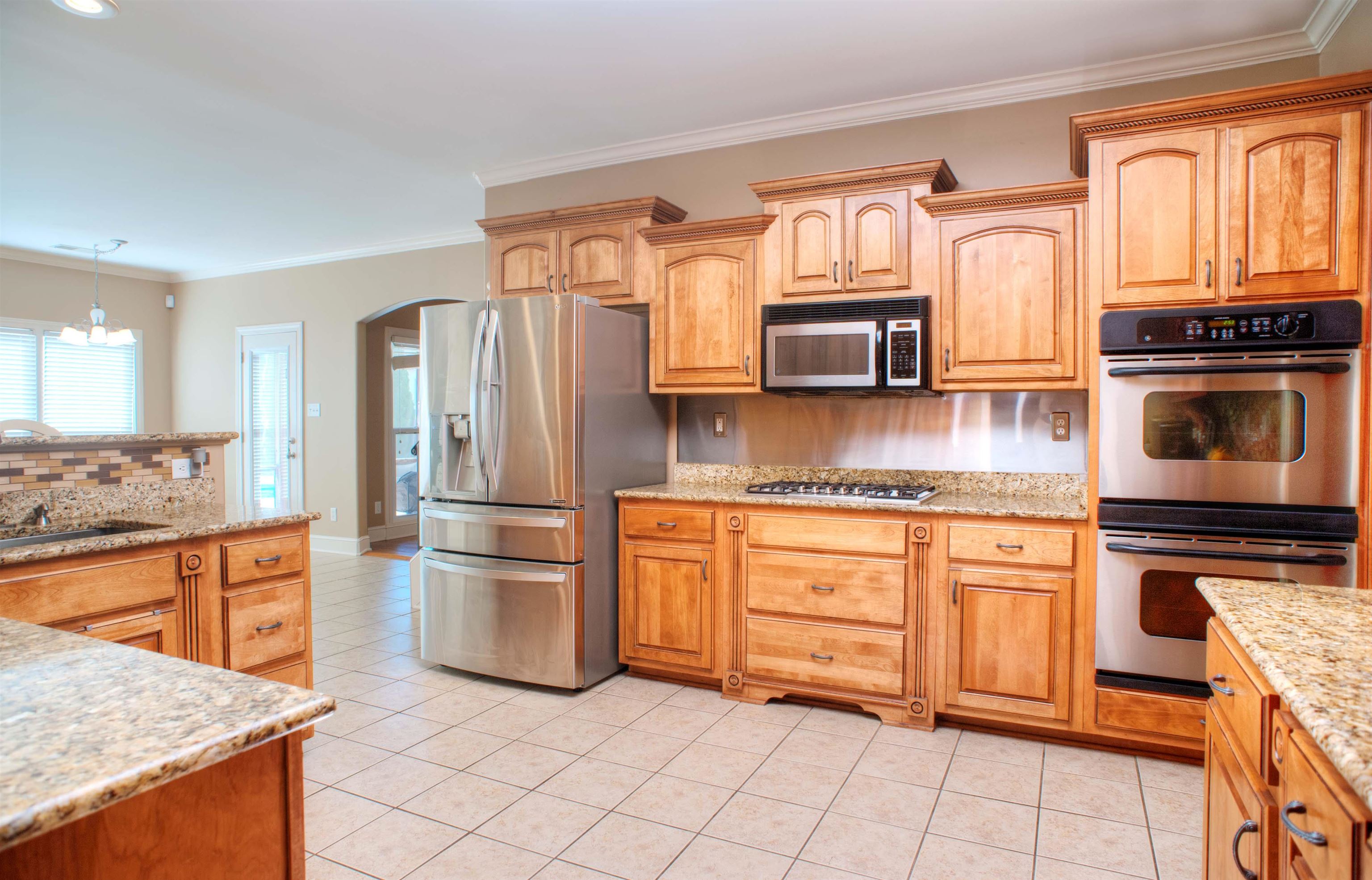 495 Tribal Woods Road Collierville, TN 38017 - Photo 6 of 22 Fabulous Updated Kitchen with Tile Floor, LED Lighting, Granite Counters, Custom Backsplash, New Deep Farm Sink, Stainless Appliances including New 5 Burner Gas Cooktop and Dishwasher and Breakfast Bar..