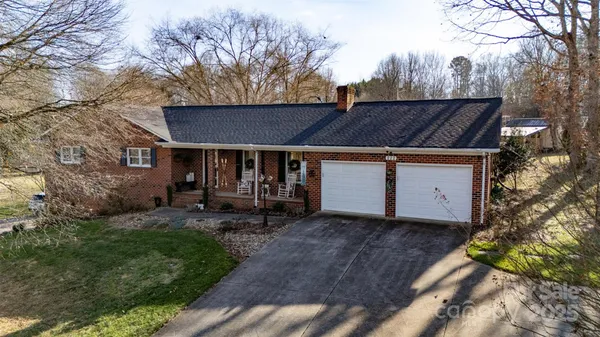 a view of a house with a yard garage and outdoor seating