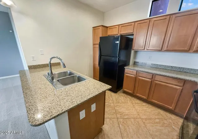 a kitchen with stainless steel appliances granite countertop a sink a refrigerator and a stove