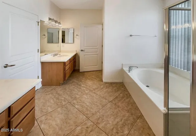 a bathroom with a tub sink and mirror