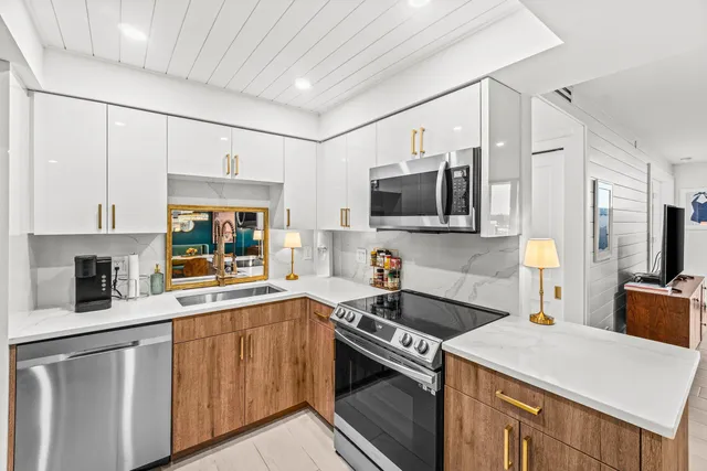 a kitchen that has a lot of cabinets and wooden floor