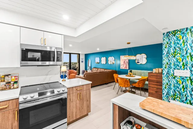 a kitchen with stainless steel appliances kitchen island granite countertop a table and chairs in it