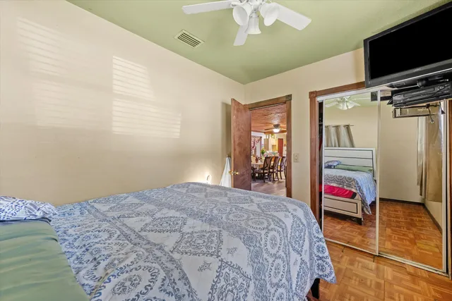 a bedroom with a bed and a flat tv screen on the dresser