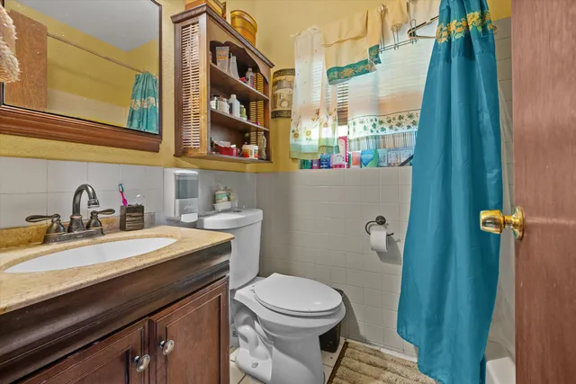 a bathroom with a sink a toilet and shower curtain