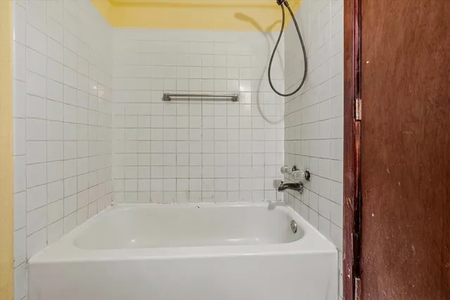 a bathroom with a bath tub with a shower