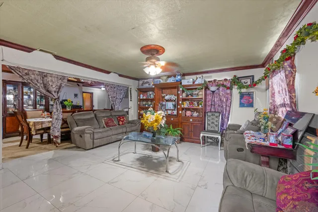 a living room with patio furniture and a chandelier