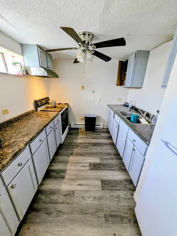 a kitchen with sink stove and cabinets