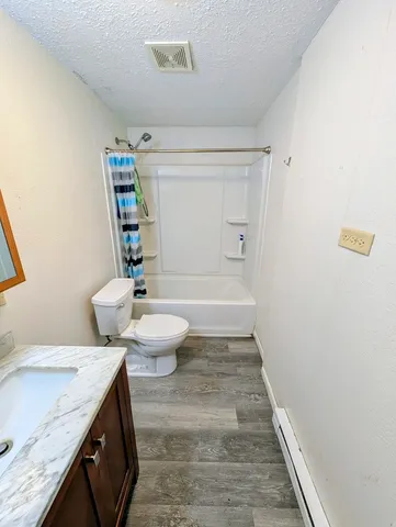 a bathroom with a granite countertop sink a toilet and bathtub