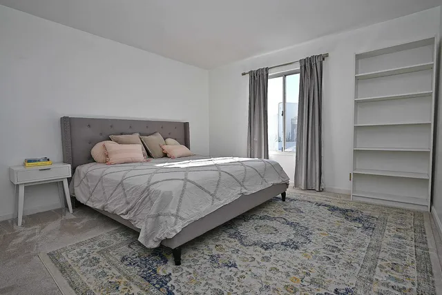 a bedroom with a bed and a window