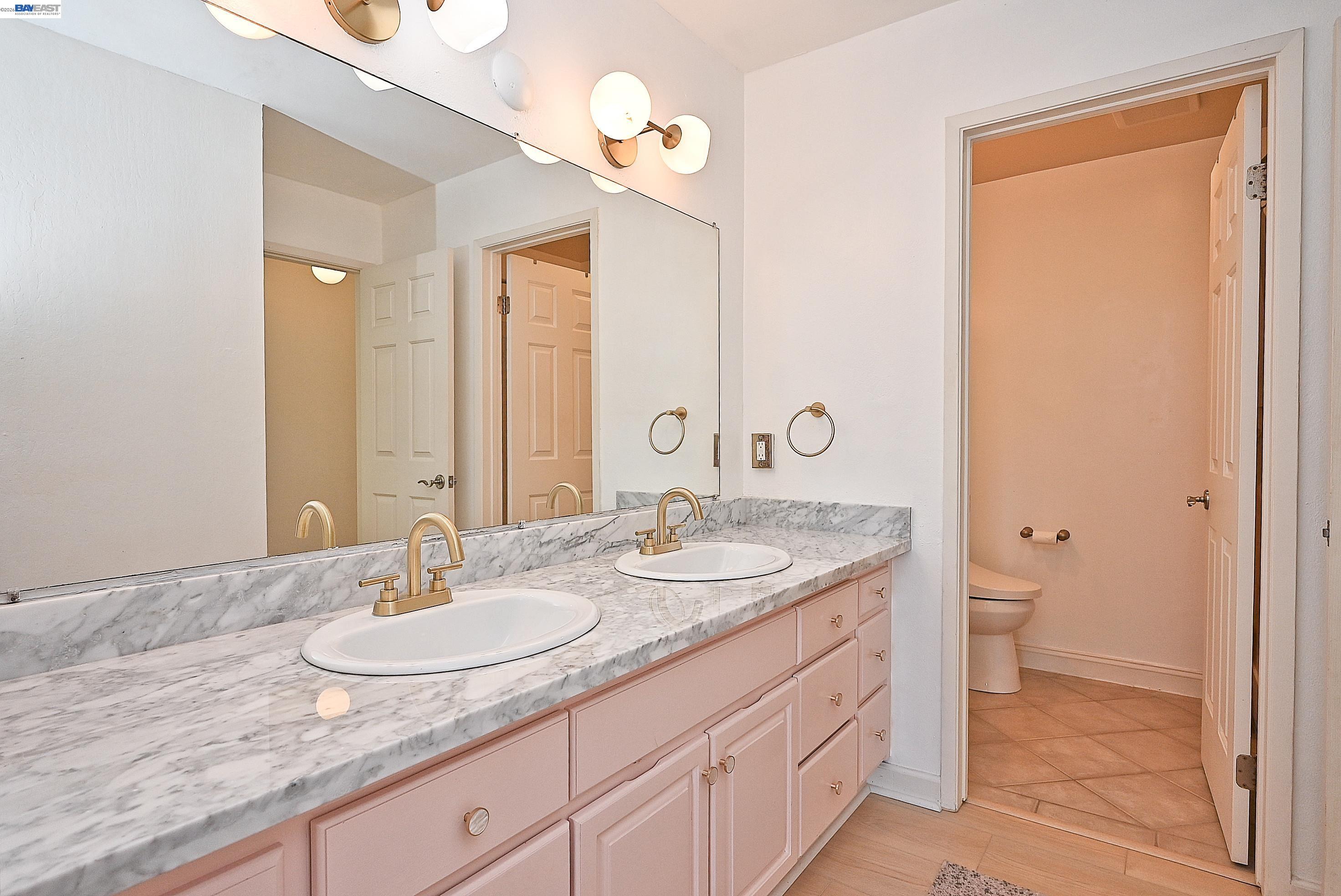 960 Shorepoint Court, Unit 215 Alameda, CA 94501 - Photo 10 of 22 a bathroom with a granite countertop sink and a mirror