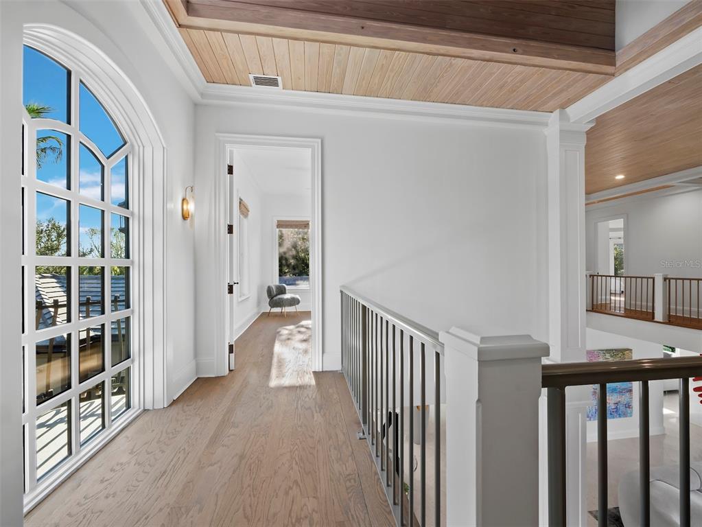 65 Lighthouse Point Drive Longboat Key, FL 34228 - Photo 37 of 90 a view of a hallway with wooden floor and windows