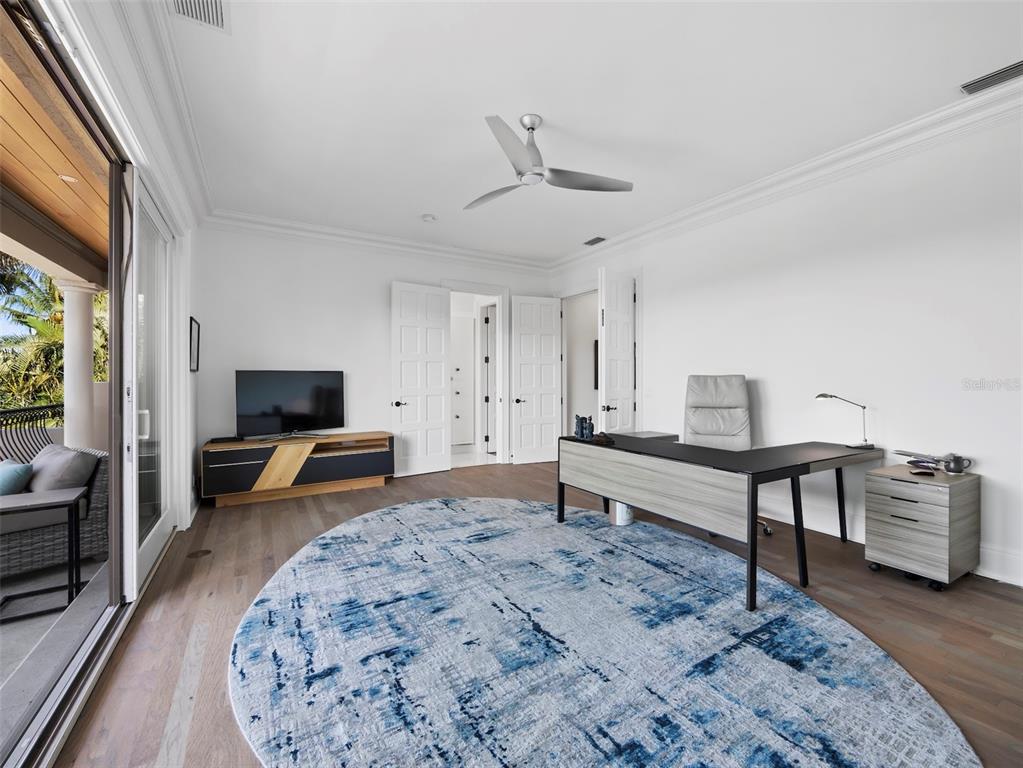 65 Lighthouse Point Drive Longboat Key, FL 34228 - Photo 45 of 90 a bedroom with furniture and a wooden floor