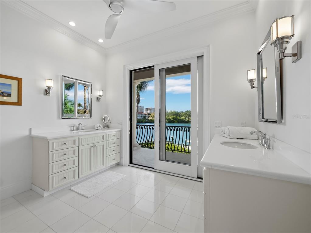 65 Lighthouse Point Drive Longboat Key, FL 34228 - Photo 51 of 90 a spacious bathroom with a double vanity sink a mirror a bathtub and next to a window