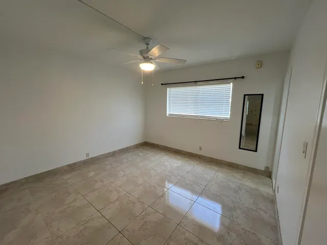 an empty room with windows and fan