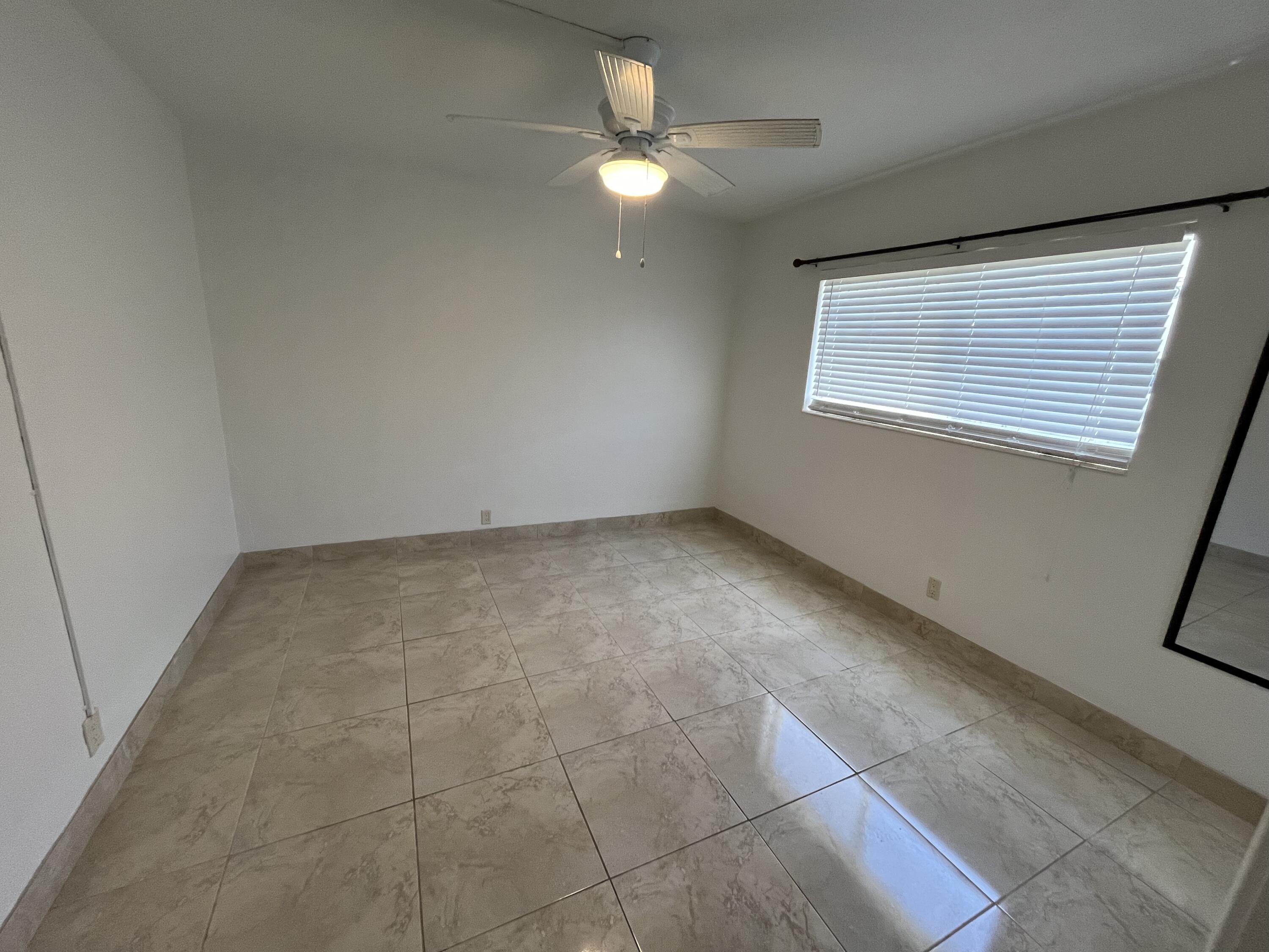 3220 Northeast 10th Street, Unit 4 Pompano Beach, FL 33062 - Photo 12 of 20 a view of an empty room with a window