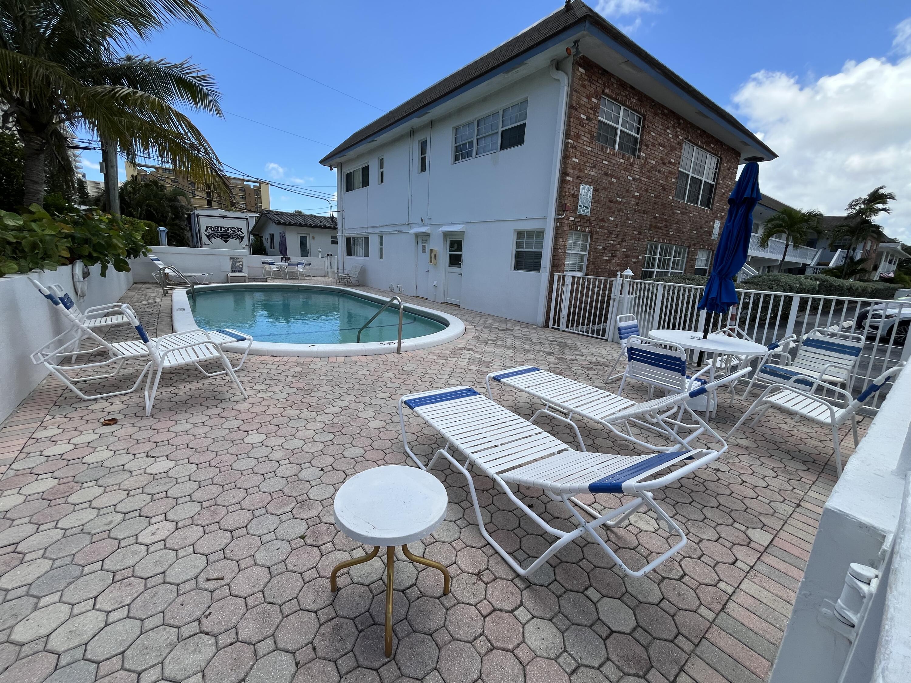 3220 Northeast 10th Street, Unit 4 Pompano Beach, FL 33062 - Photo 18 of 20 a view of a patio with table and chairs with wooden floor and fence