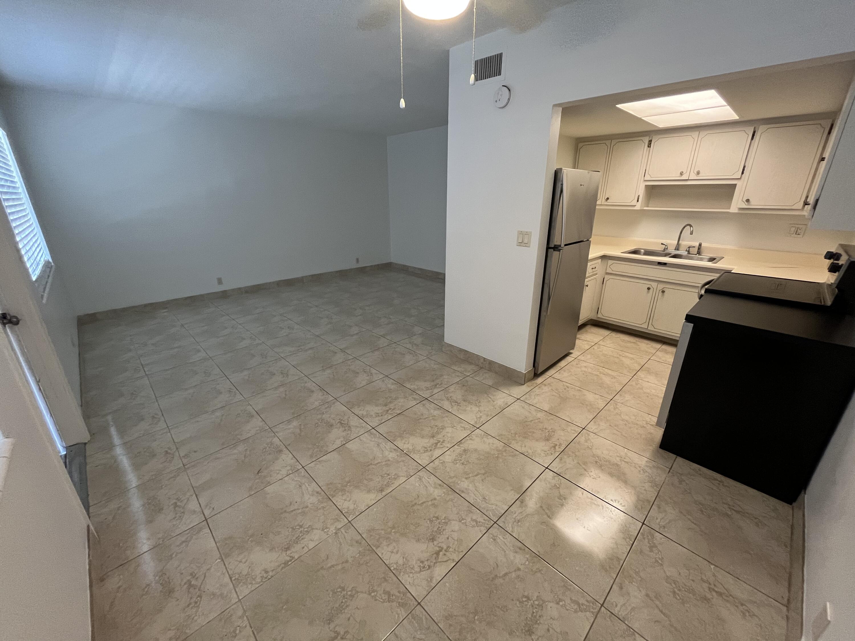 3220 Northeast 10th Street, Unit 4 Pompano Beach, FL 33062 - Photo 2 of 20 a kitchen with granite countertop a refrigerator and a stove top oven