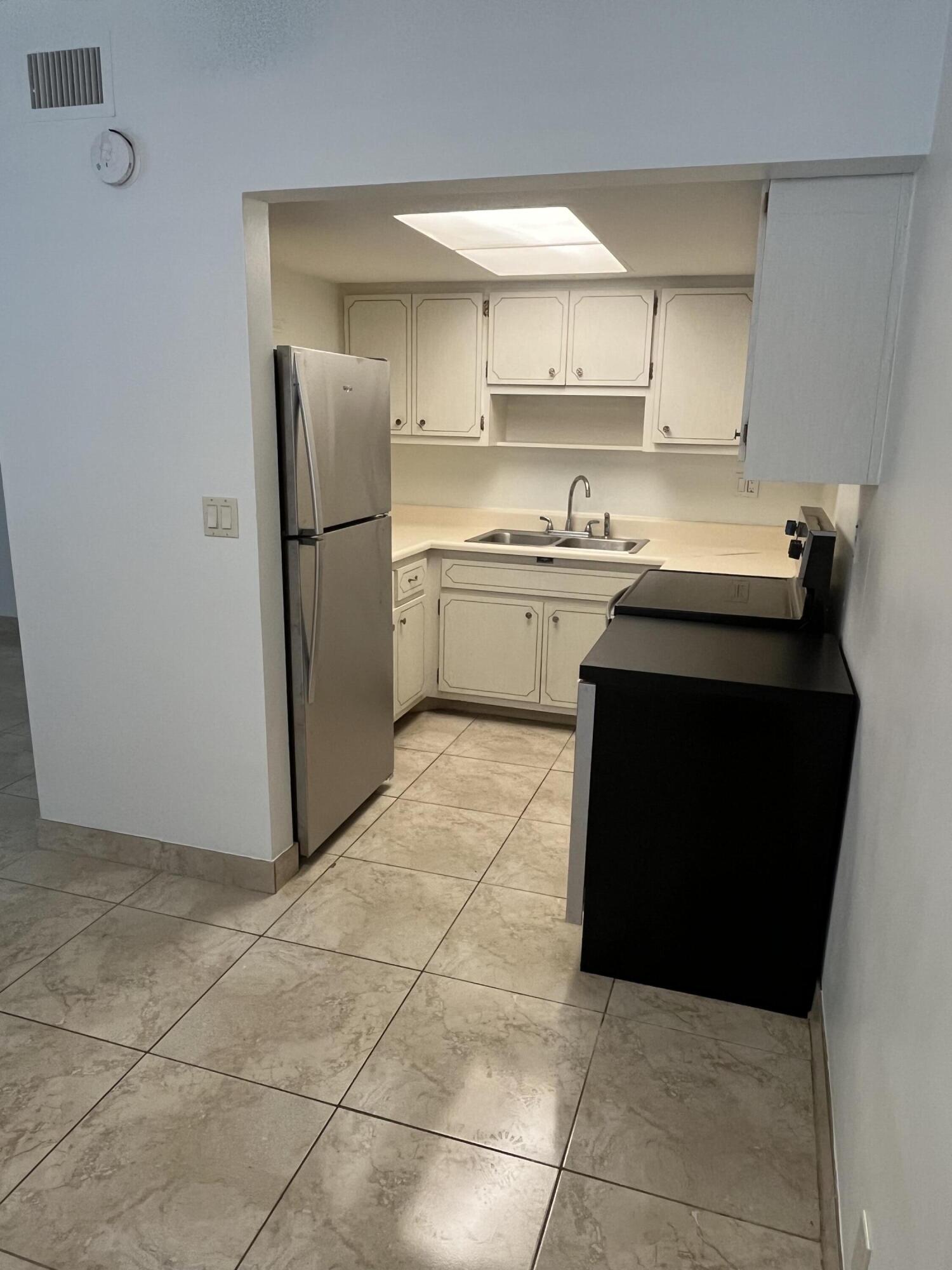 3220 Northeast 10th Street, Unit 4 Pompano Beach, FL 33062 - Photo 4 of 20 a kitchen with a sink a stove and a refrigerator