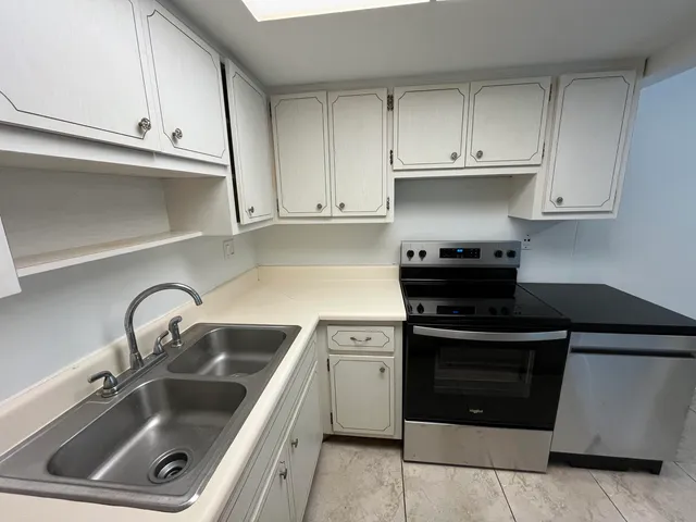 a kitchen with white cabinets and a stove top oven