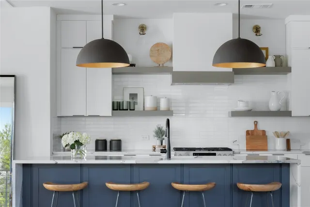 a kitchen with stainless steel appliances granite countertop a sink a stove and a wooden floors