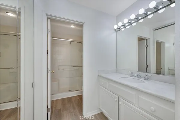 a bathroom with a granite countertop sink a large mirror and a shower