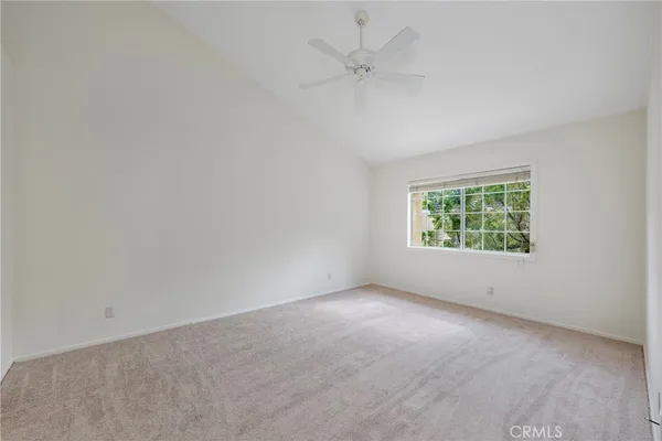 an empty room with a window and a ceiling fan