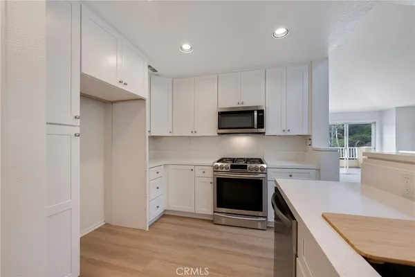a kitchen with stainless steel appliances granite countertop a stove a sink and a refrigerator