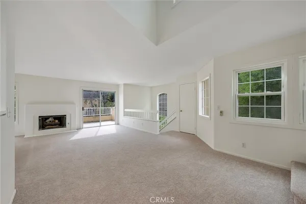an empty room with fireplace and windows