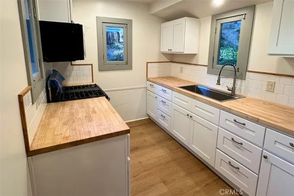 a kitchen with a sink and a stove top oven