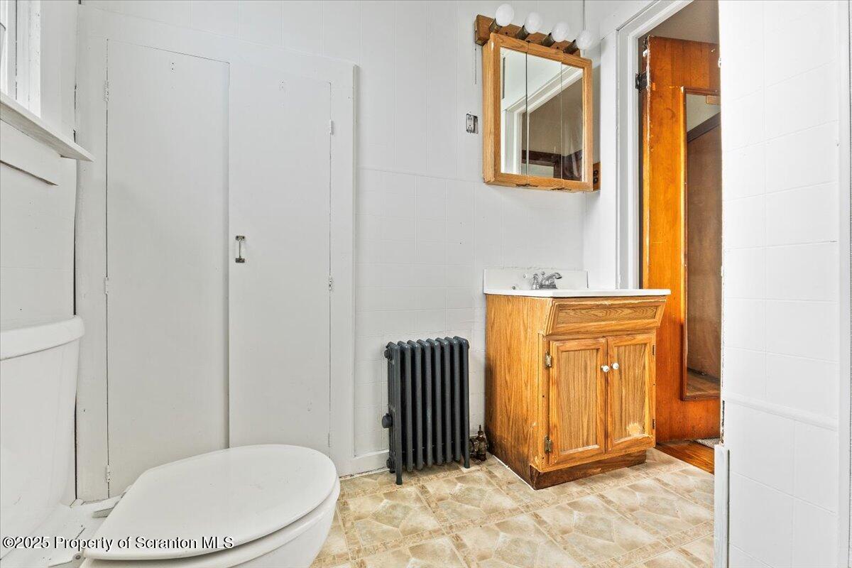 131 Stephenson Street Duryea, PA 18642 - Photo 9 of 28 a bathroom with a toilet a sink and mirror