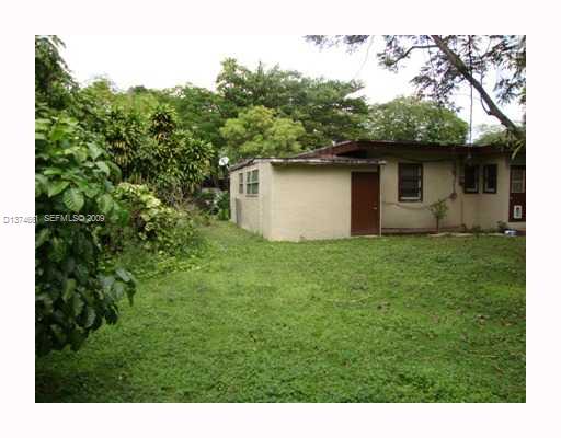5942 Southwest 60th Street Miami, FL 33143 - Photo 13 of 14 a view of a backyard with plants and a large tree