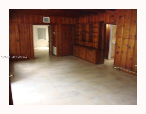 5942 Southwest 60th Street Miami, FL 33143 - Photo 7 of 14 a view of an empty room with wooden door