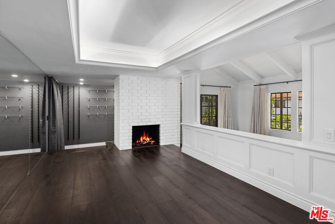 1060 Chantilly Road Los Angeles, CA 90077 - Photo 11 of 40 a view of an empty room with wooden floor fireplace and a window