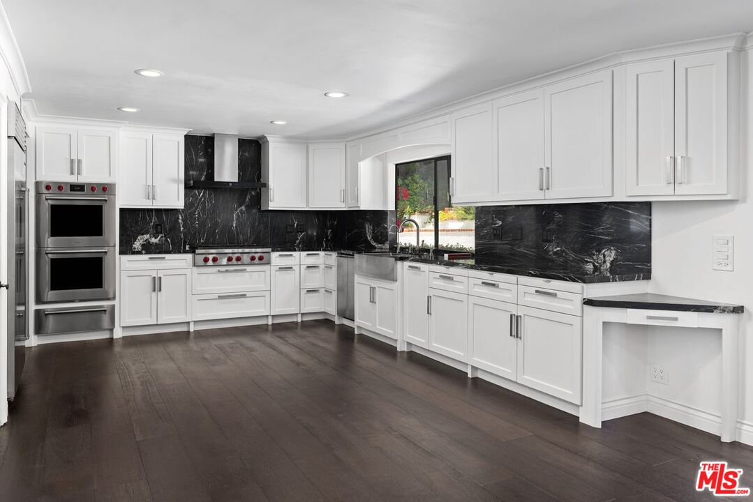 1060 Chantilly Road Los Angeles, CA 90077 - Photo 17 of 40 a kitchen with granite countertop a stove a sink and a microwave