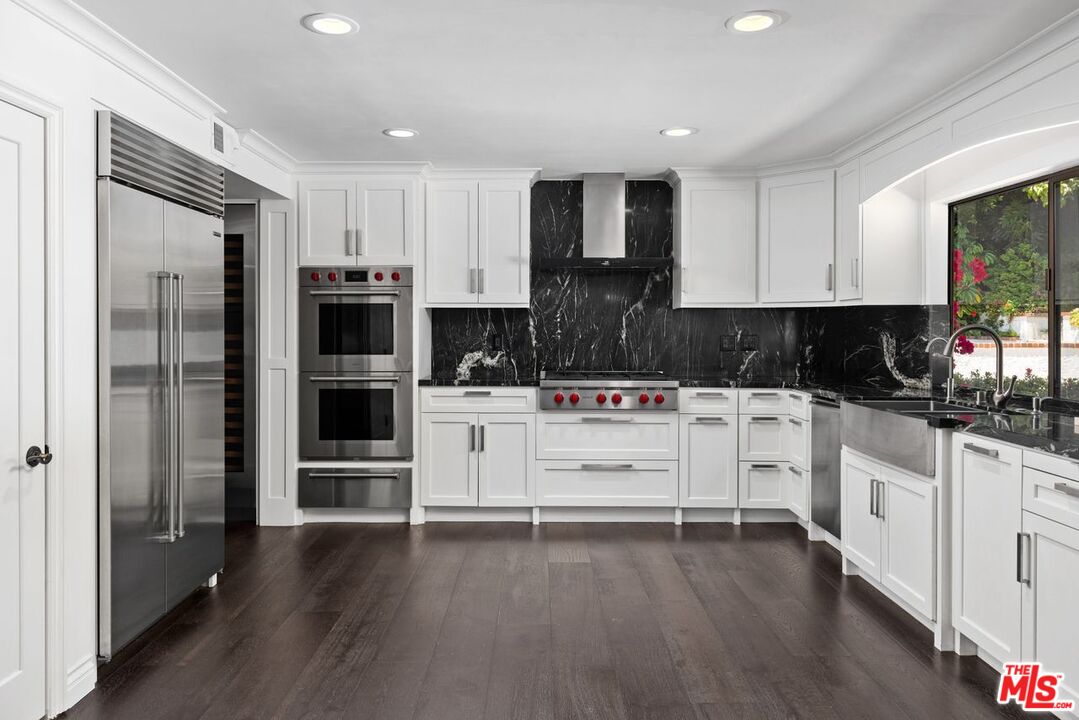 1060 Chantilly Road Los Angeles, CA 90077 - Photo 18 of 40 a kitchen with white cabinets and stainless steel appliances
