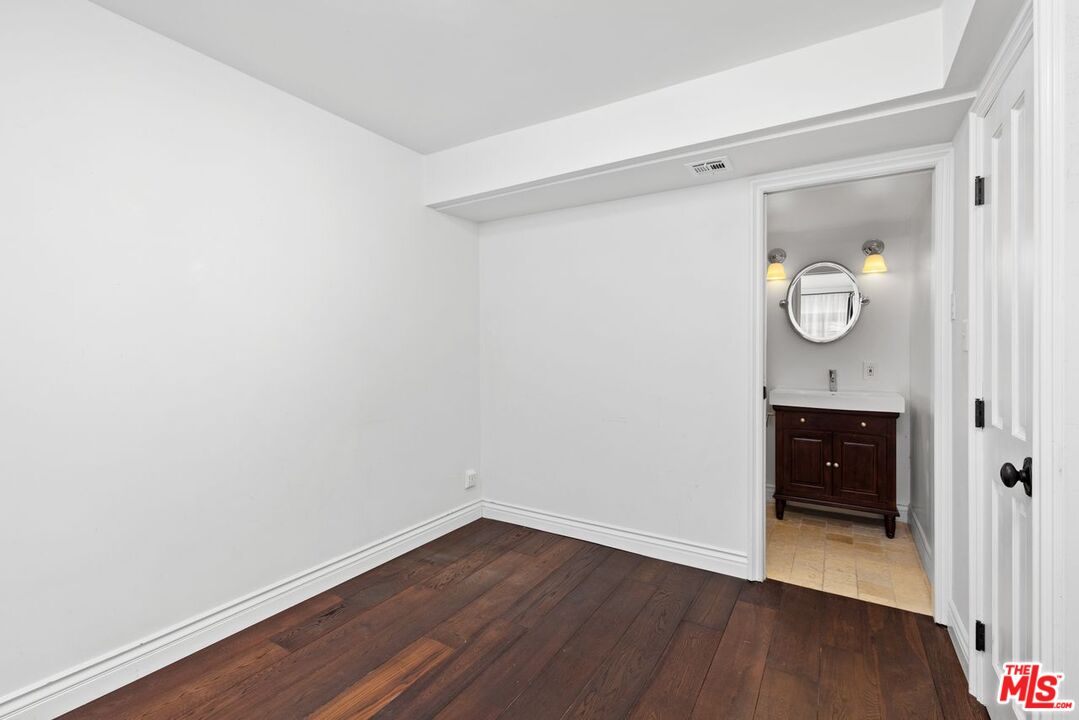 1060 Chantilly Road Los Angeles, CA 90077 - Photo 24 of 40 a view of an empty room with wooden floor and a window